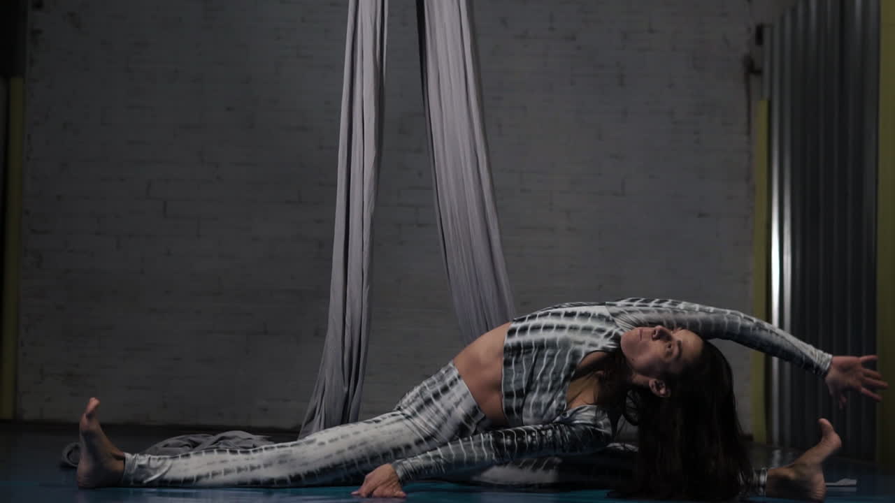 expresiva ejecutante acrobática latina haciendo un estiramiento de sujeción de flexión lateral