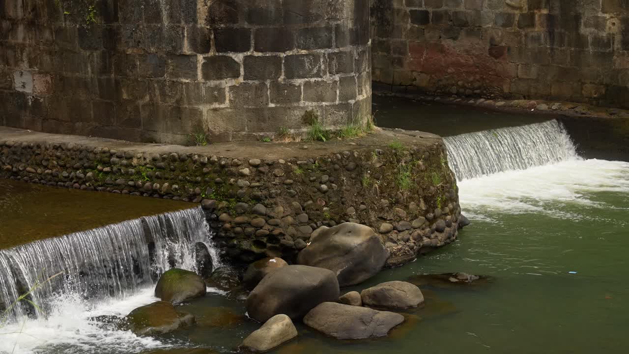 Waterfall under a stone bridge