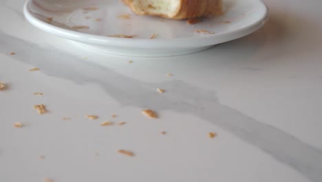 crumbs from a croissant on a marble table