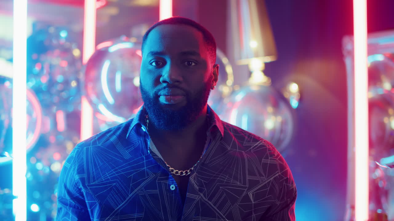 hombre afroamericano divirtiéndose en el fondo de neón. hombre aplaudiendo en el club