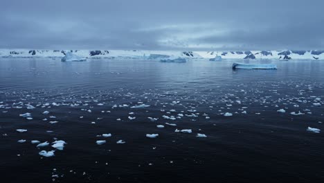 Dark-Moody-Winter-Coastal-Seascape,-Antarctica-Ocean-Scenery-with-Iceberg-Mountains-and-Sea,-Beautiful-Dramatic-Blue-Coast-Landscape-on-Antarctic-Peninsula,-Icy-Winter-Sea-Scene-with-Ice