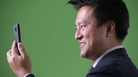 녹색 배경에 성숙한 일본 사업가