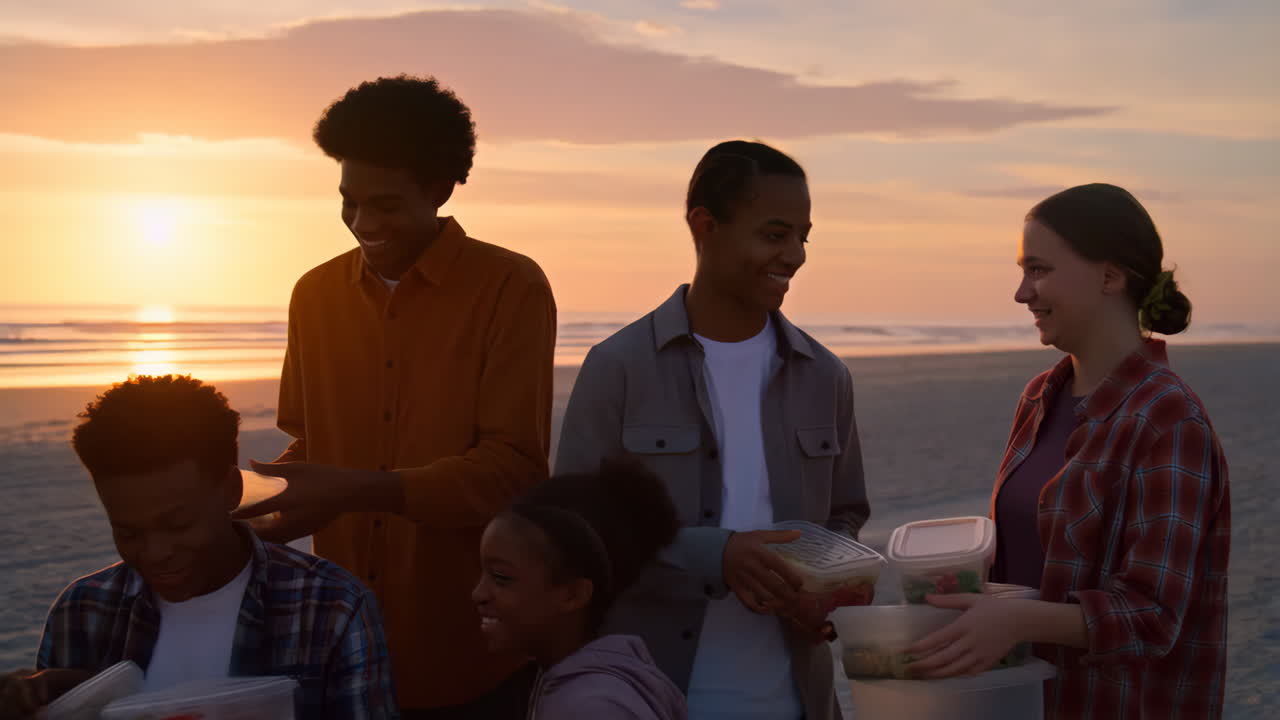 Diverse friends enjoying a beach picnic at sunset