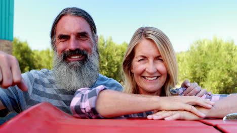 happy couple leaning on tractor in olive farm 4k