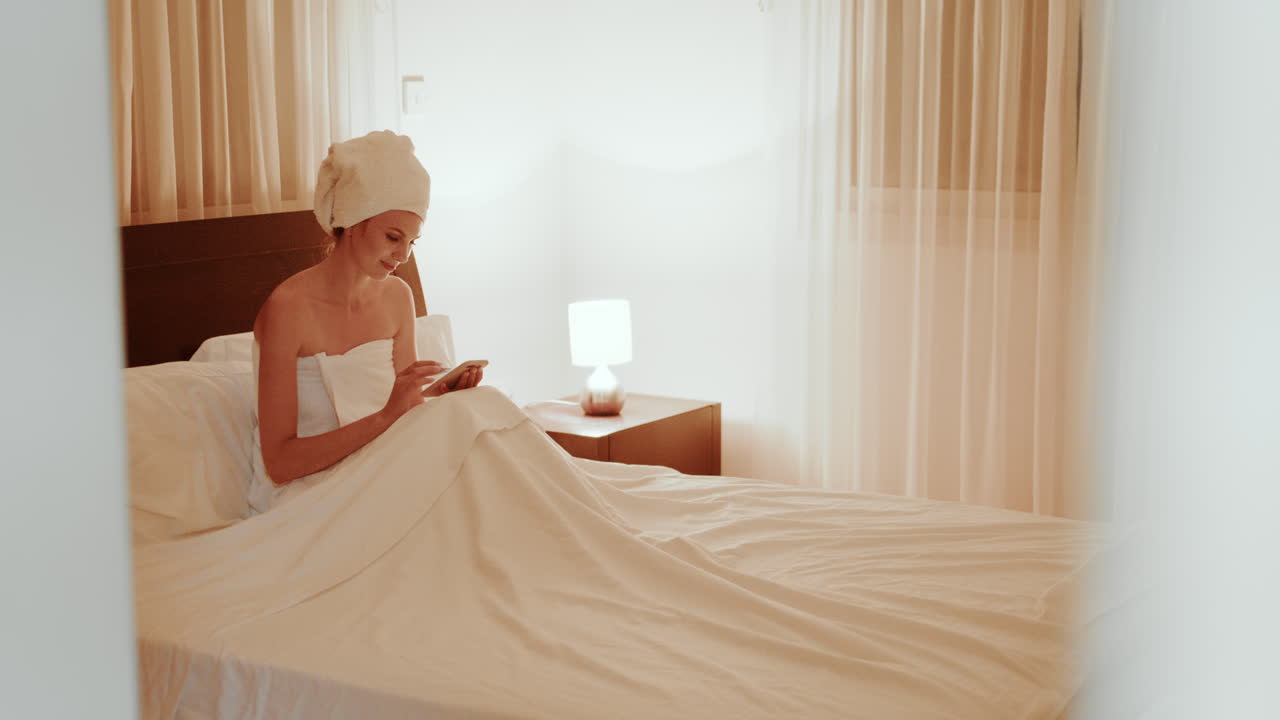 밤에 침대에서 드폰을 사용하는 여자