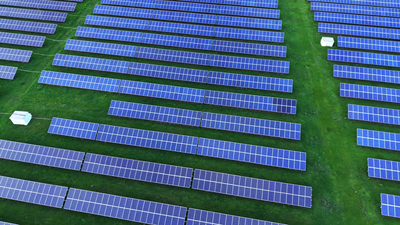 Expansive solar panel array in a green field under bright sunlight