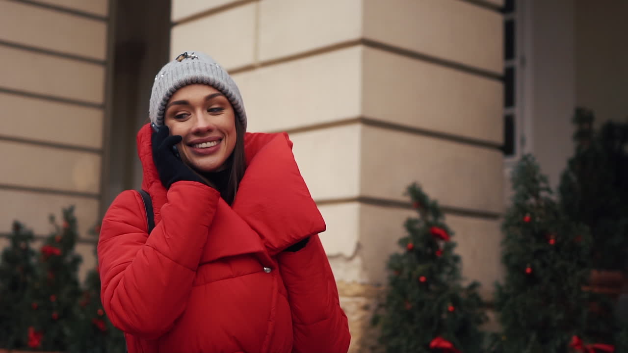 Woman in red coat making a phone call outdoors