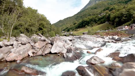 FPV-aerial-drone-footage-along-river-and-under-bridge-to-Lavertezzo,-Switzerland