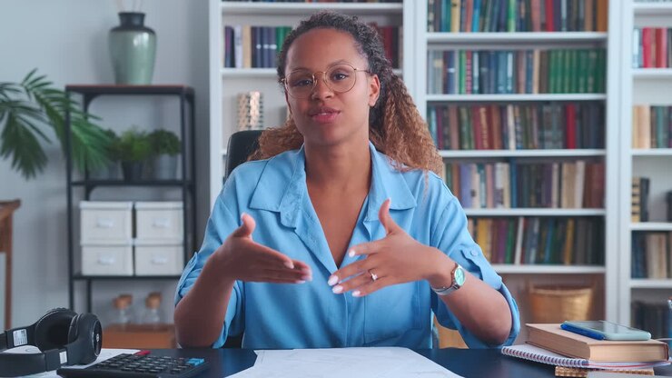 Giovane donna afroamericana che registra un video curriculum, seduta alla scrivania nel suo ufficio domestico.