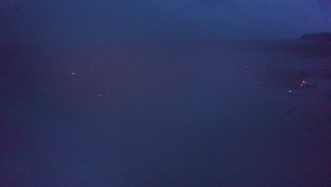 a peaceful drone shot glides through morning mist, slowly revealing an icelandic church surrounded by fog-kissed fields and distant snow-covered hills.