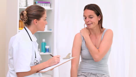 patient showing her painful shoulder to her doctor