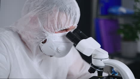 científico usando el microscopio en un laboratorio