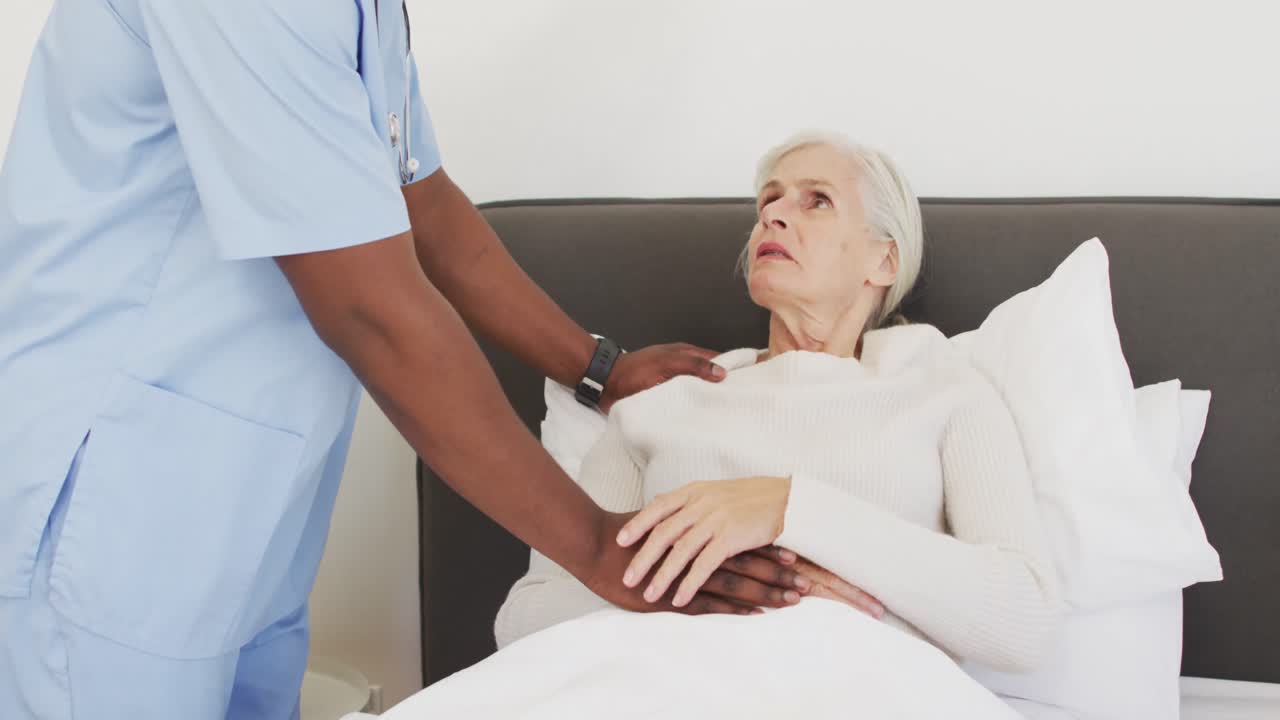 video de la sección media de un médico afroamericano apoyando a una mujer caucásica mayor