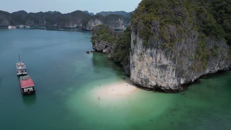 aerial-shot-of-boats-docked-by-private-beach-cove-in-Cat-Ba-and-Halong-Bay-in-Northern-Vietnam