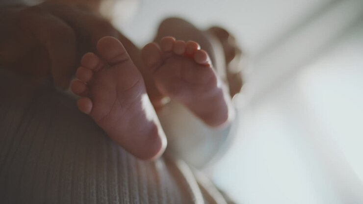 Baby Feet Held by Mother