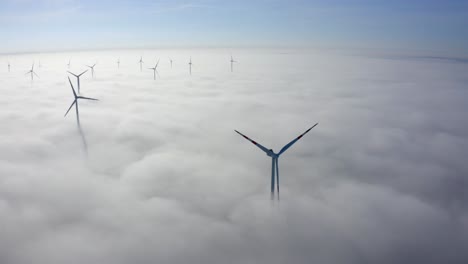 idyllic view of wind turbines over misty clouds during daylight