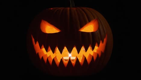 a creepy jack-o'-lantern glows mysteriously in the darkness, showcasing its sinister grin and menacing eyes perfect for halloween festivities and spooky atmosphere