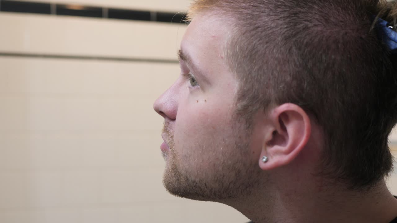 남자는 정신적 쇠약이 있고 슬로우 모션 4k에서 머리카락을 윙윙거립니다.