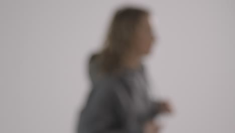 Defocused-Studio-Shot-Of-Young-Woman-Having-Fun-Dancing-Against-White-Background