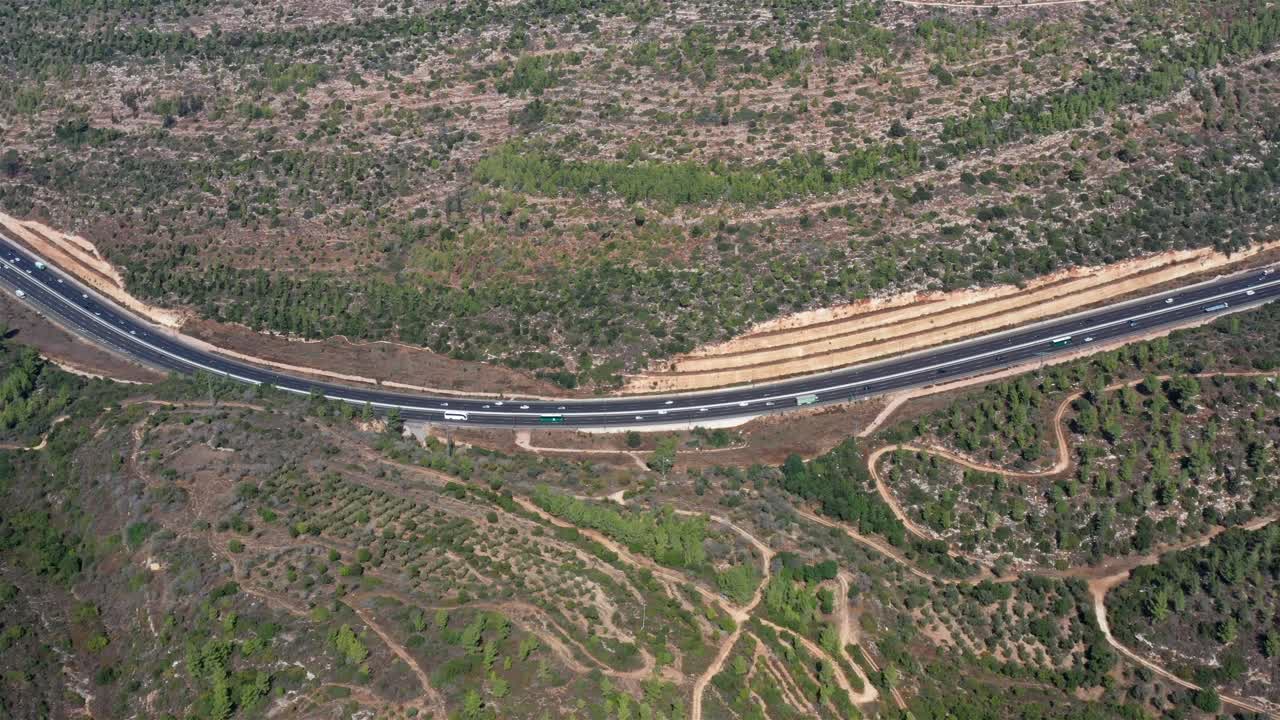 산악 지형 을 가로질러 휘어지는 고속도로 의 공중 사진