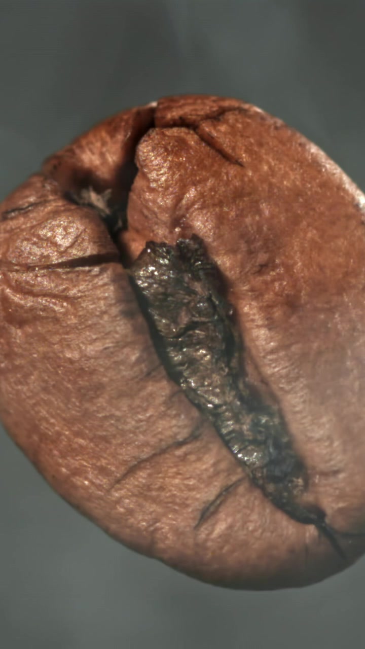 Macro di un chicco di caffè caldo con vapore che sale