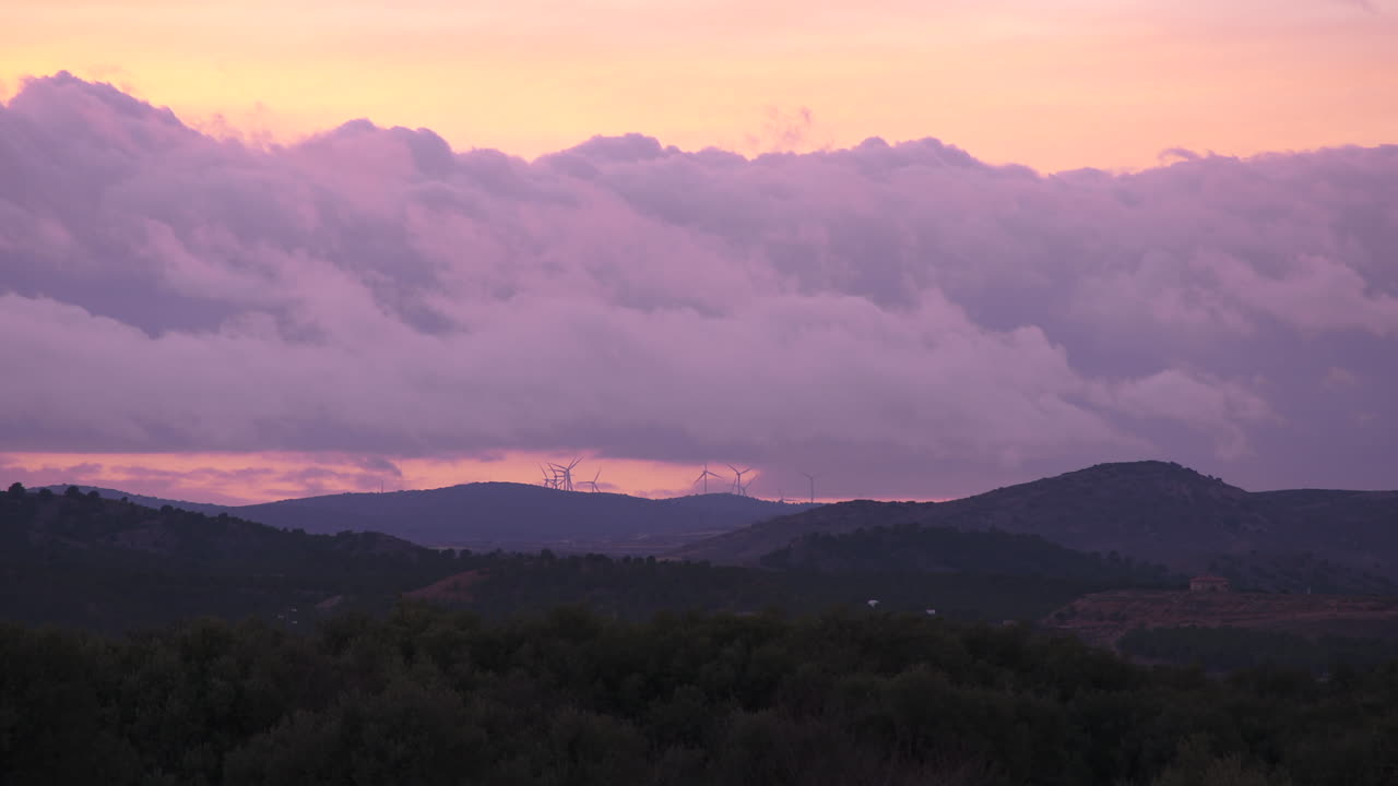 cielo al atardecer con turbinas de viento en la distancia