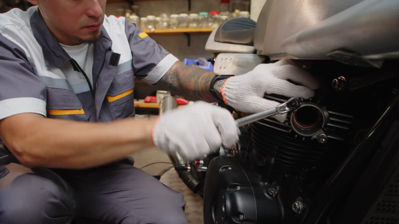 Male Mechanic Fixing Tires on Motorbike