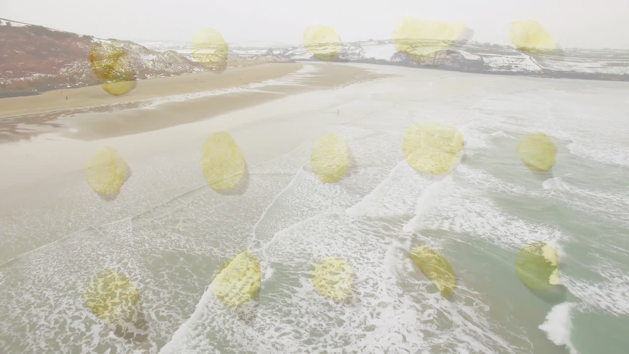 Animation of waves crashing on sandy beach with yellow abstract shapes overlay