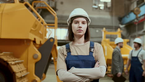 portrait of female technician posing with arms crossed in industrial factory