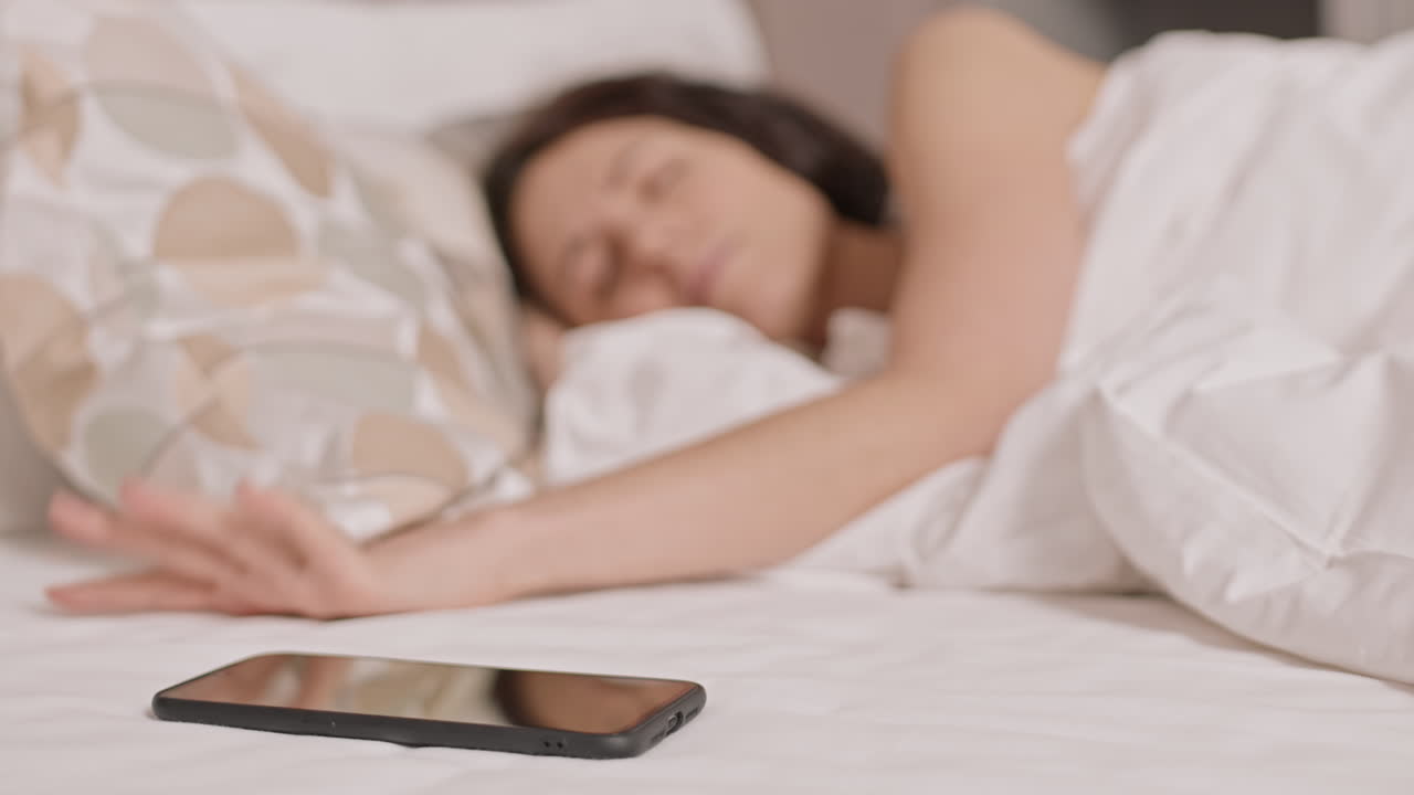 Blurred Woman Turning off Alarm Clock