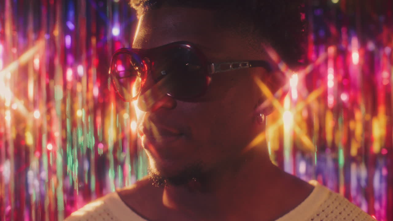 Stylish African American Man in Sunglasses Illuminated by Colorful Lights