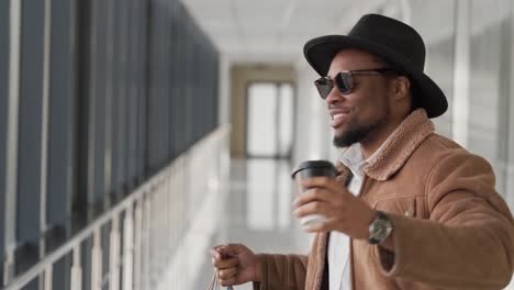 Handsome-black-guy-walks-down-the-hall-dancing-with-shopping-bags-at-mall