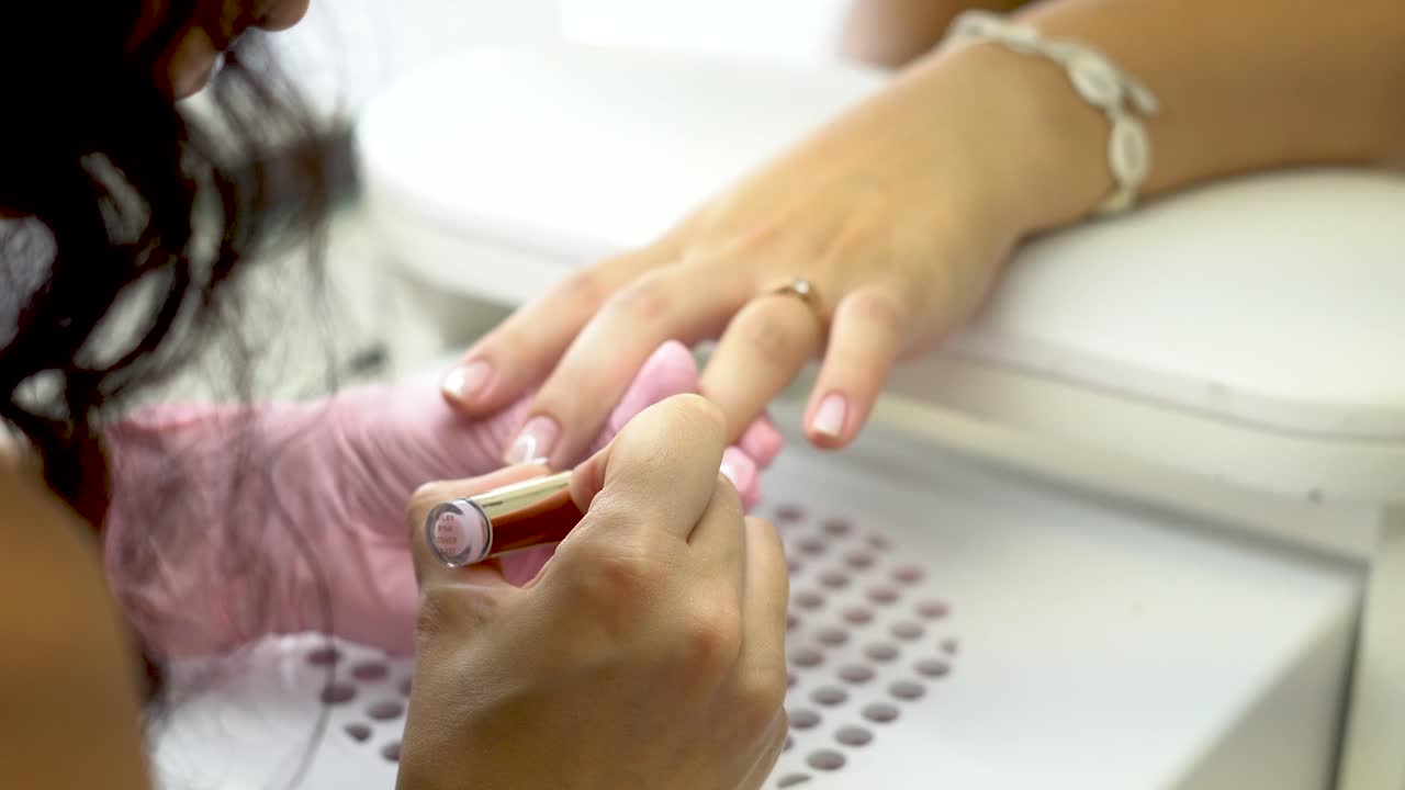 Esthéticienne manucurant délicatement les jolis ongles de ses clientes