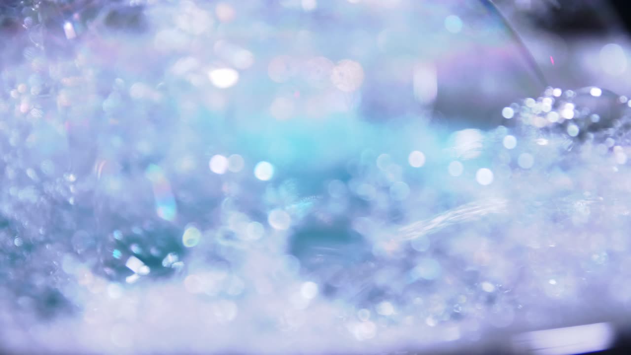 회전 슬로우 모션 및 파란색 복사 공간 배경이 있는 예술적 흐림 거품 및 점