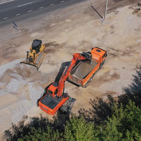 excavator pours sand into the truck
