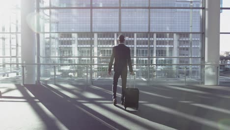 Businessman-standing-with-luggage-in-the-lobby-at-office-4k