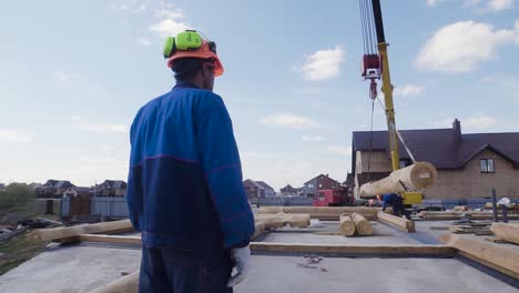 house construction site with crane and workers