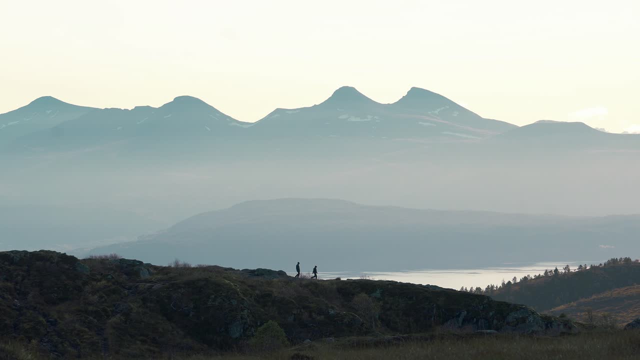 멀리 있는 작은 산 위를 걷는 사람들, 배경에 있는 큰 산, 노르웨이, 몰데