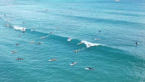 surfistas atrapando olas y divirtiéndose en un lugar popular para surfear, todo captado en 4k aéreo por un dron