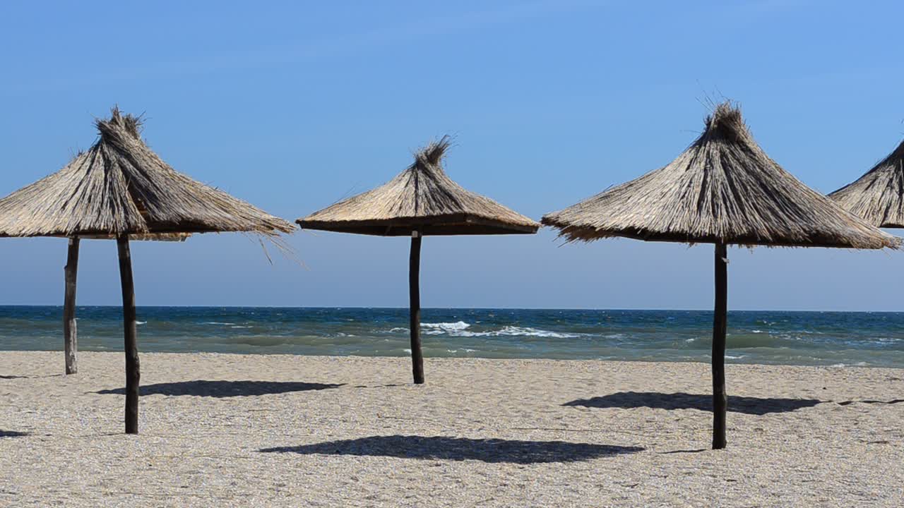 Ombrelloni di paglia sulla spiaggia. Riprese sulla spiaggia