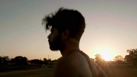 chico indio corriendo y entrenando para hacer ejercicio cardiovascular en un parque público durante la puesta de sol