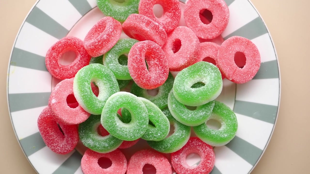 Vibrantes caramelos de goma en forma de anillo rojos y verdes cubiertos de azúcar