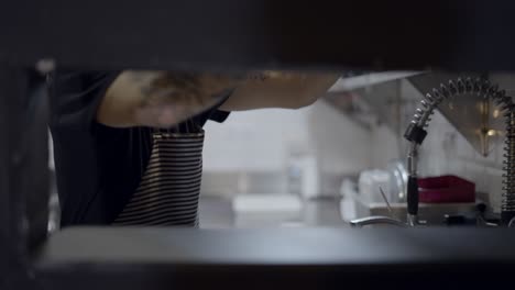 chef washing dishes in commercial kitchen