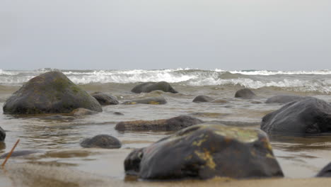 Vista-Del-Agua-Moviéndose-Entre-Piedras-En-La-Playa-De-Arena,-España,-Isla-De-Gran-Canaria