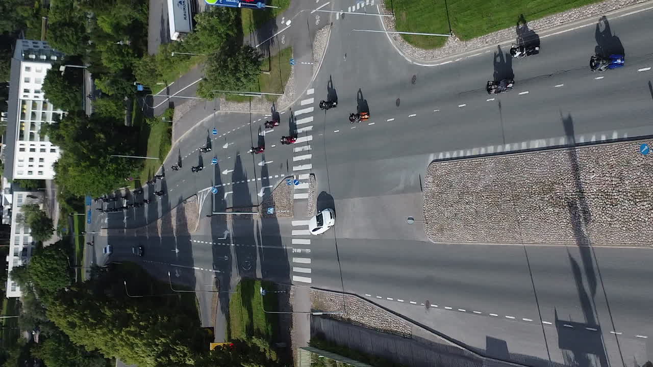 Vertical format tracks bikers on group motorcycle club ride in city