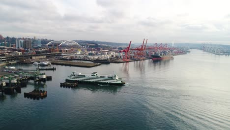 aerial shot pulling away from two ferries pulling into the seattle harbor