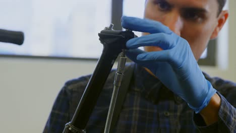 hombre reparando una bicicleta en el taller 4k