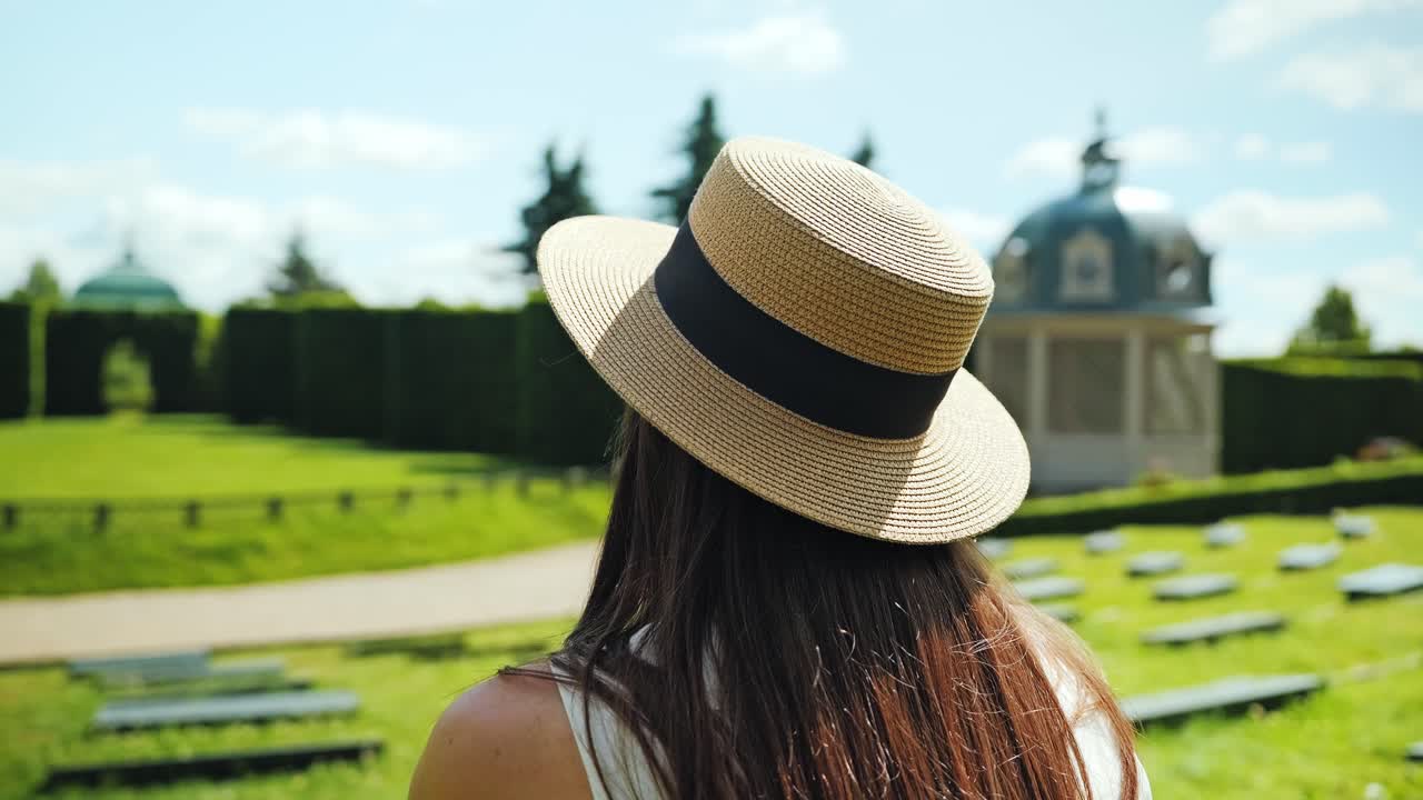 Back view of woman admiring rare open-air garden theatre in Rundāle, Latvia