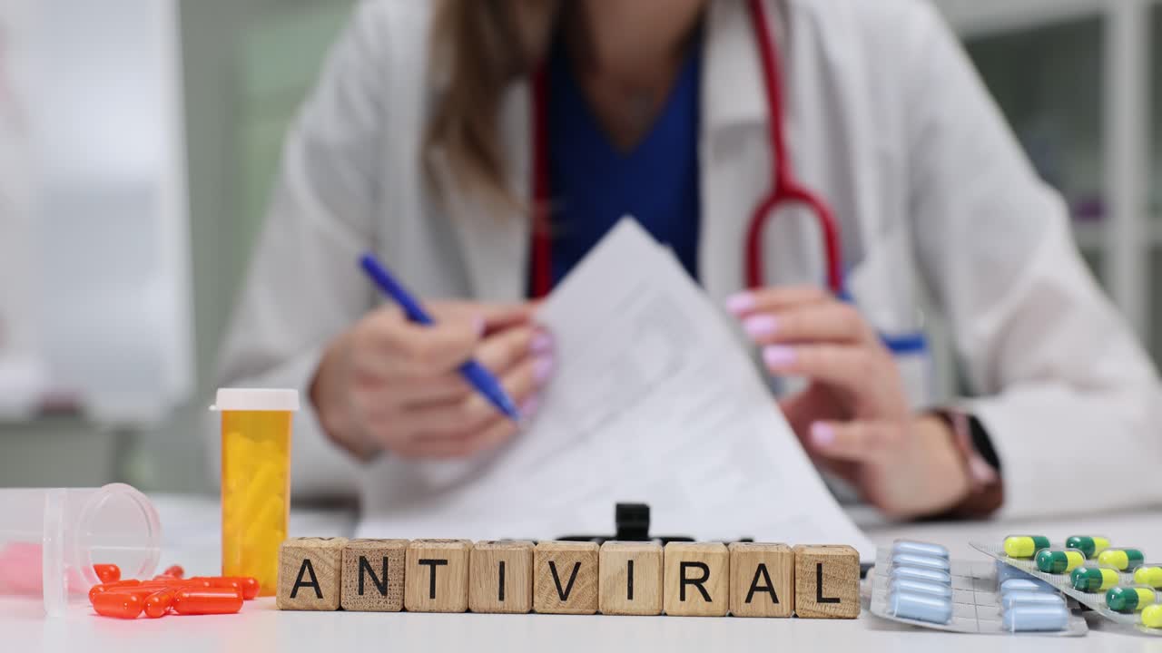 Blocos com a palavra Antiviral e medicamentos, com médico escrevendo em segundo plano.