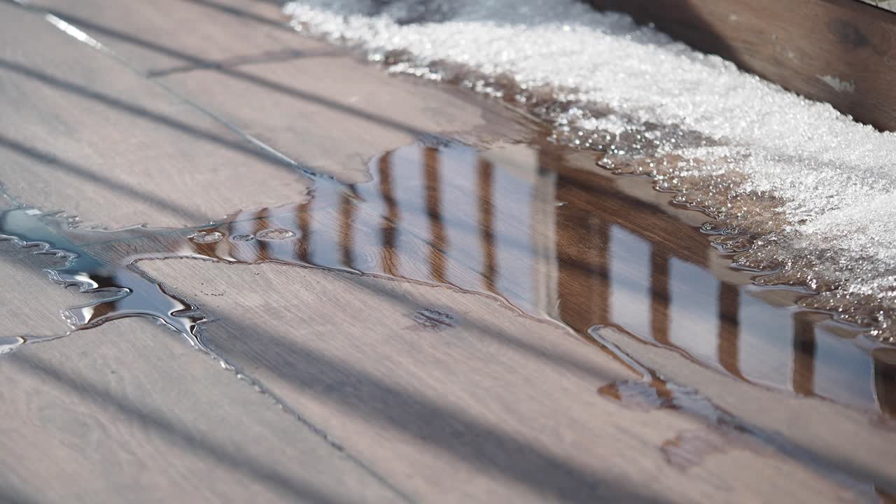 Water Puddle on Wooden Deck with Melting Snow